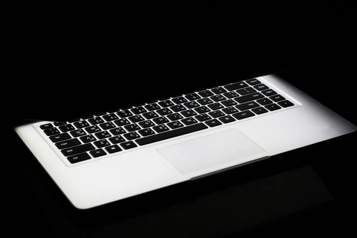 A laptop keyboard glowing in a dark room