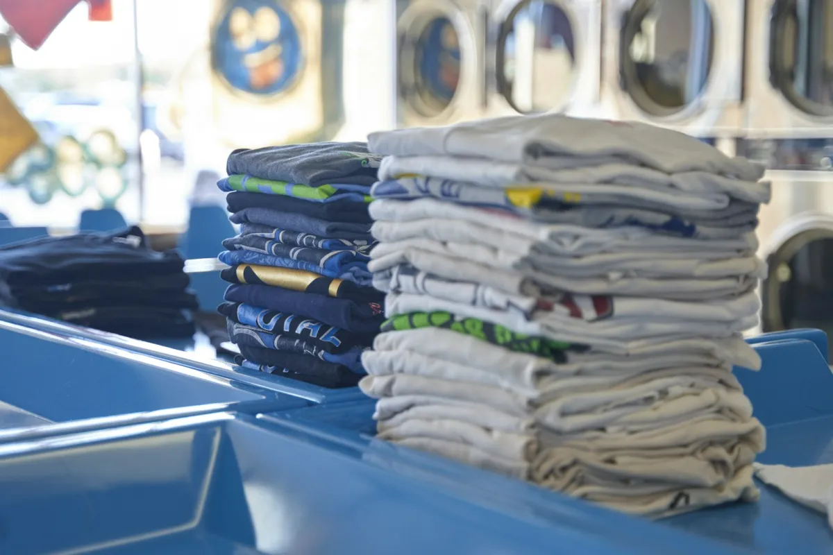 Stacks of folded T-shirts on a blue counter Stacks of folded T-shirts on a blue counter
