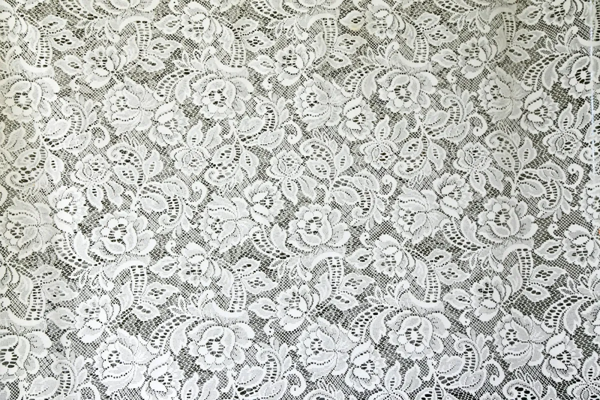 Close-up of white floral lace over a dark background Close-up of white floral lace over a dark background