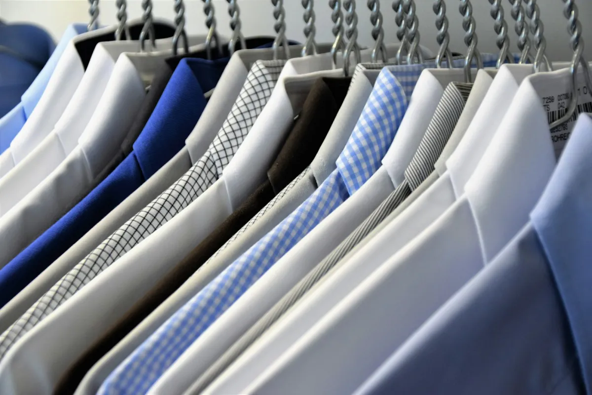Assorted dress shirts hanging on a rail