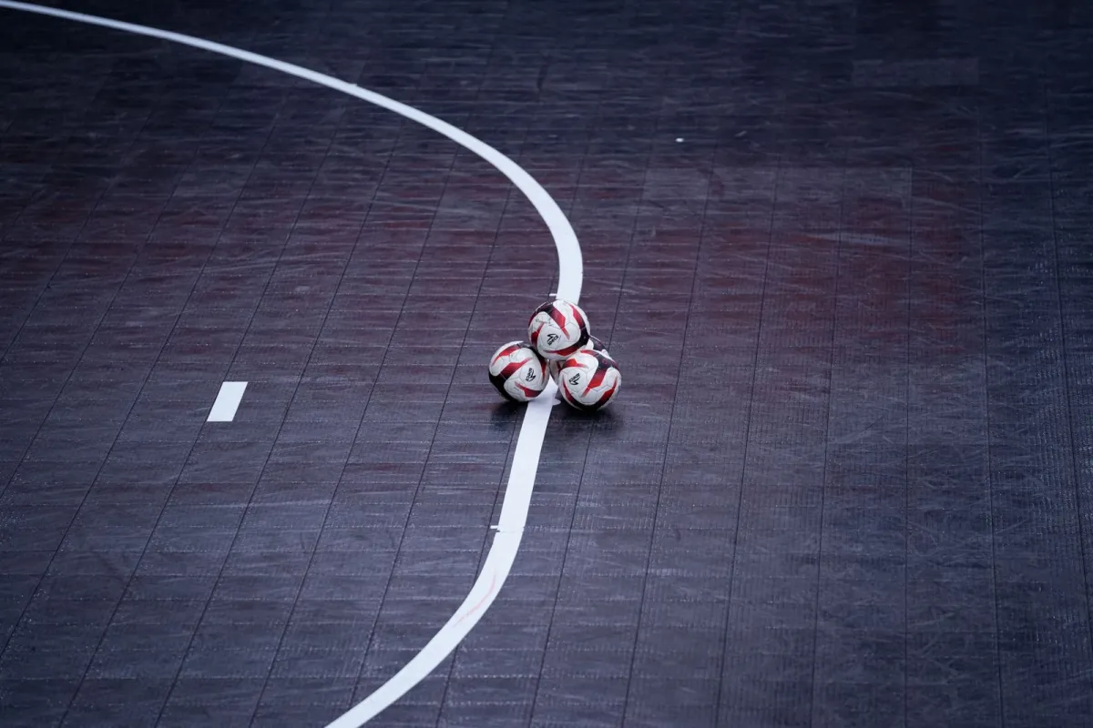 Three futsal balls resting on the line of an indoor court Three futsal balls resting on the line of an indoor court