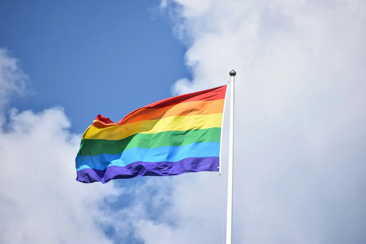 A rainbow flag flying against the sky